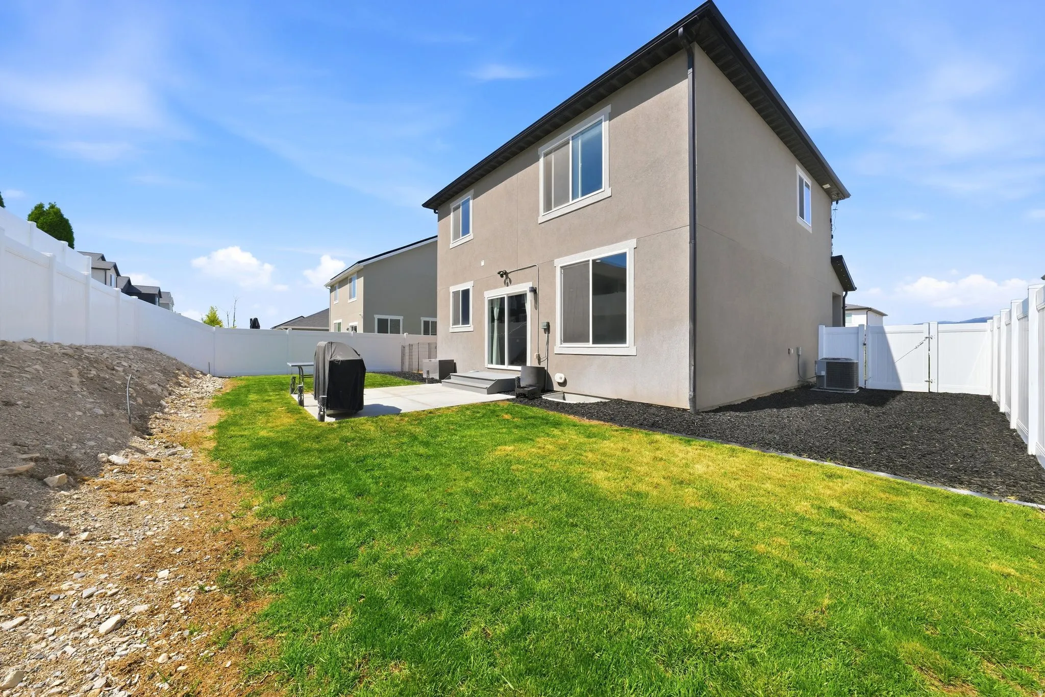 Rear exterior with a concrete patio, sliding glass door