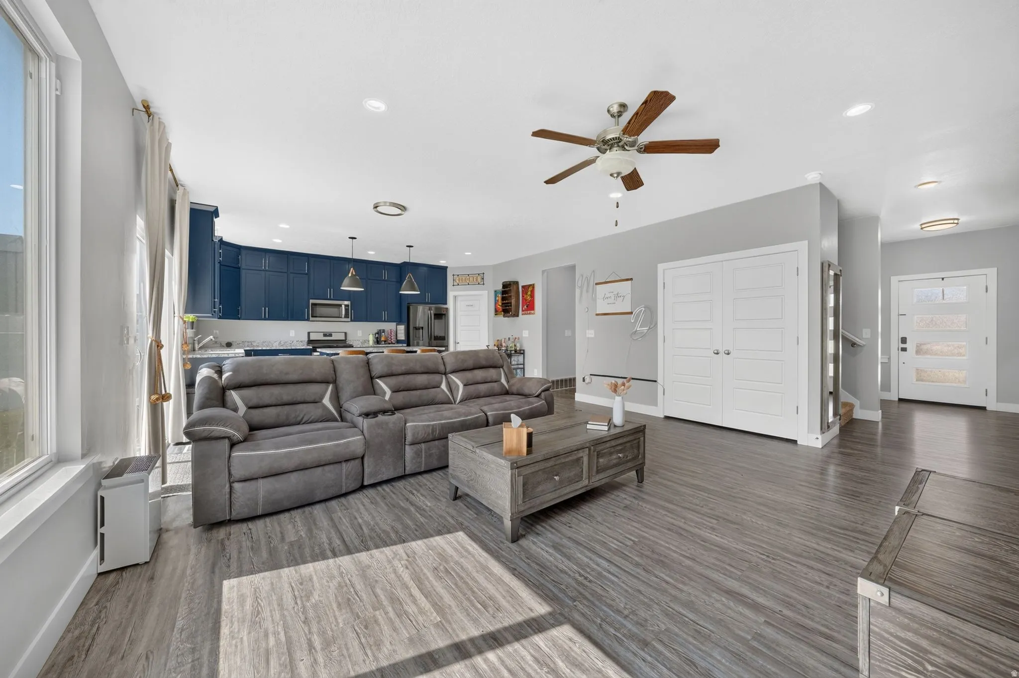 Open-concept main living area featuring wood-finish flooring, recessed lighting, and a ceiling fan