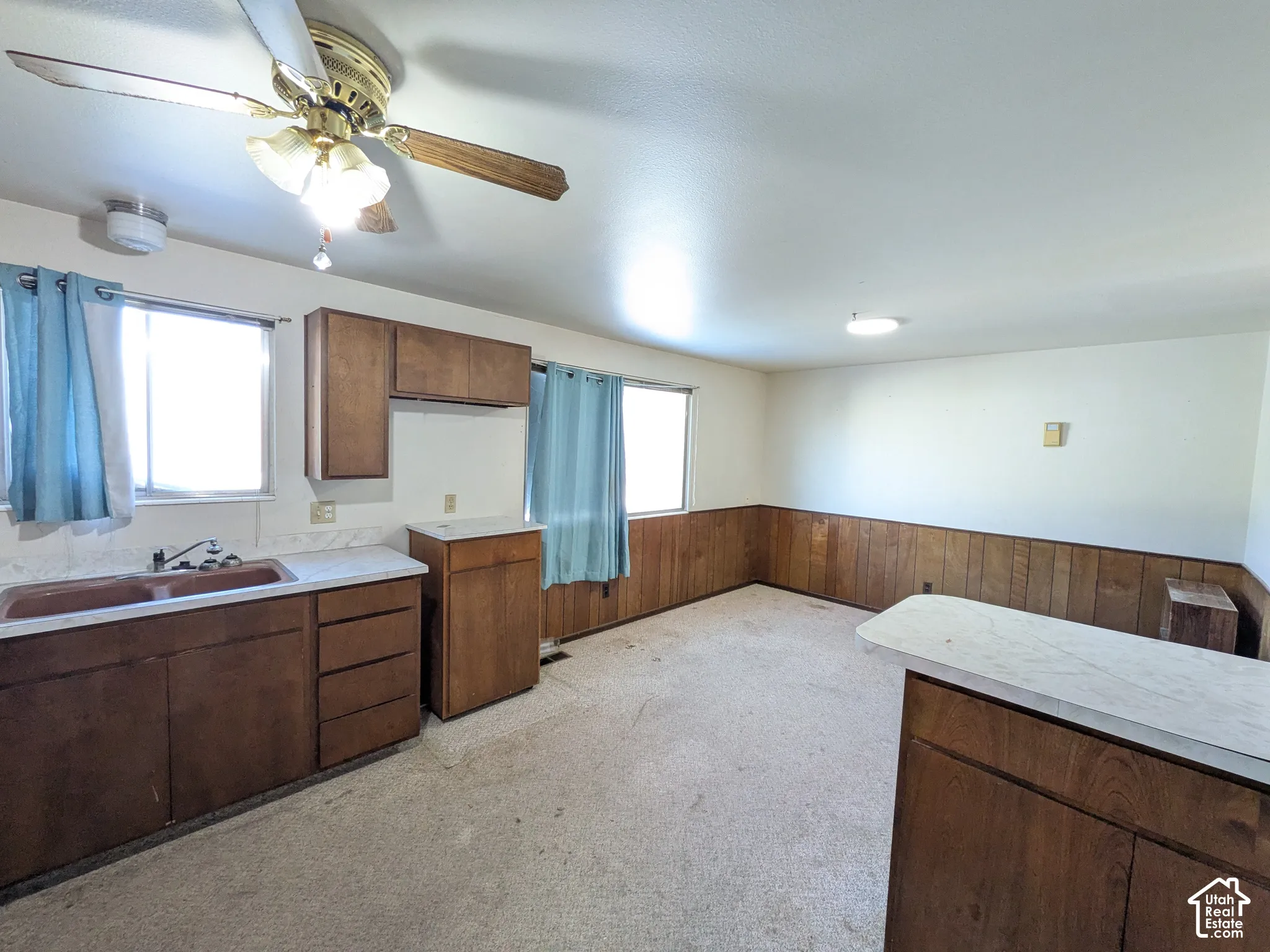 Functional kitchen area with wood-finish cabinetry and a double basin sink