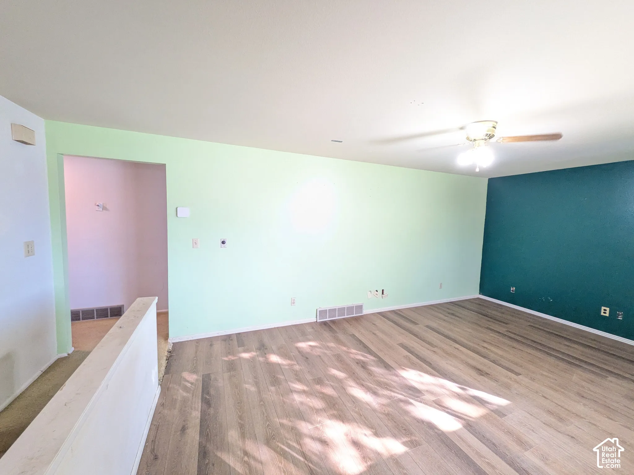 Wood-finish flooring with a ceiling fan overhead