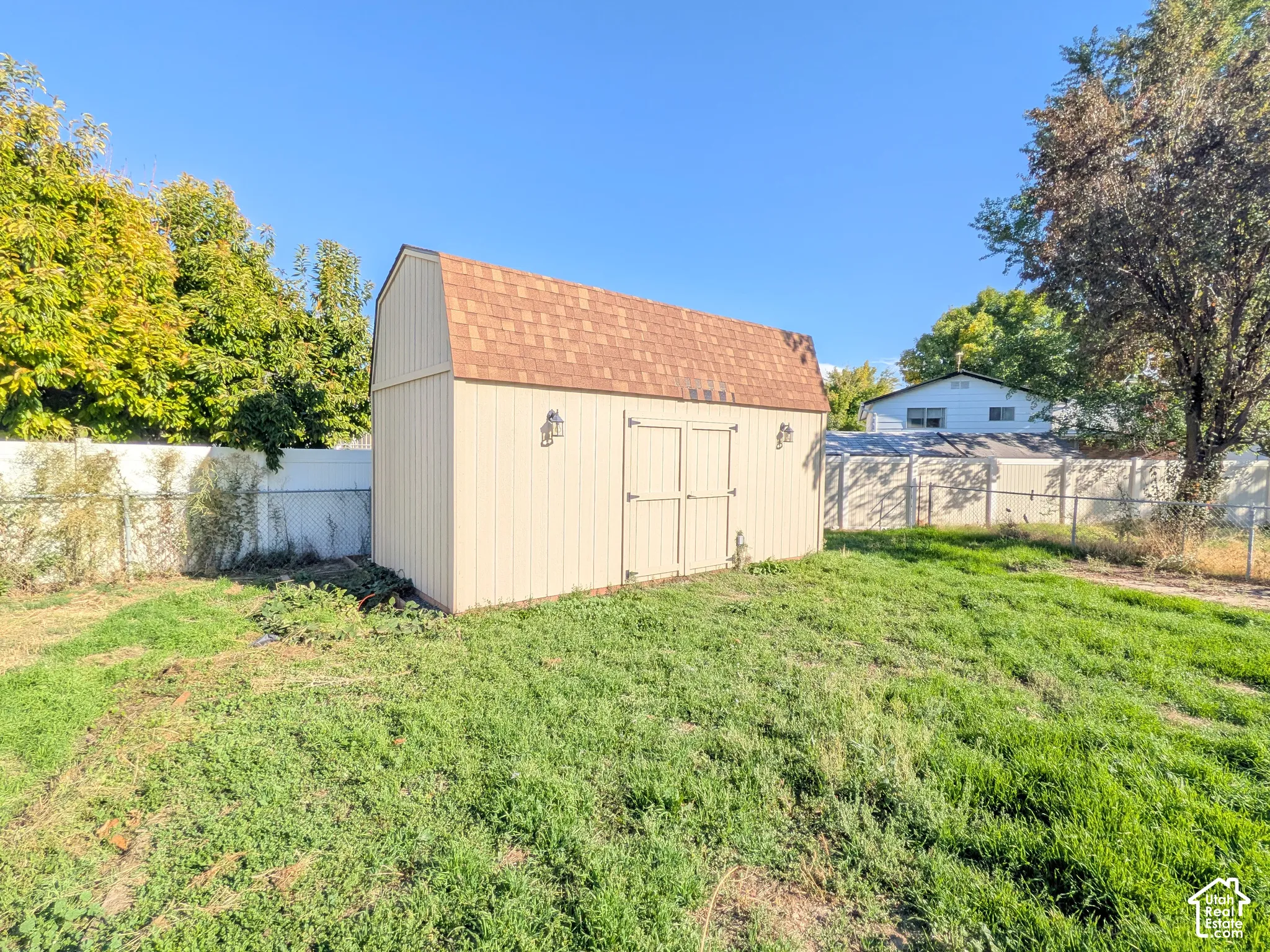 Gable roof storage shed with double doors and exterior sconce lighting