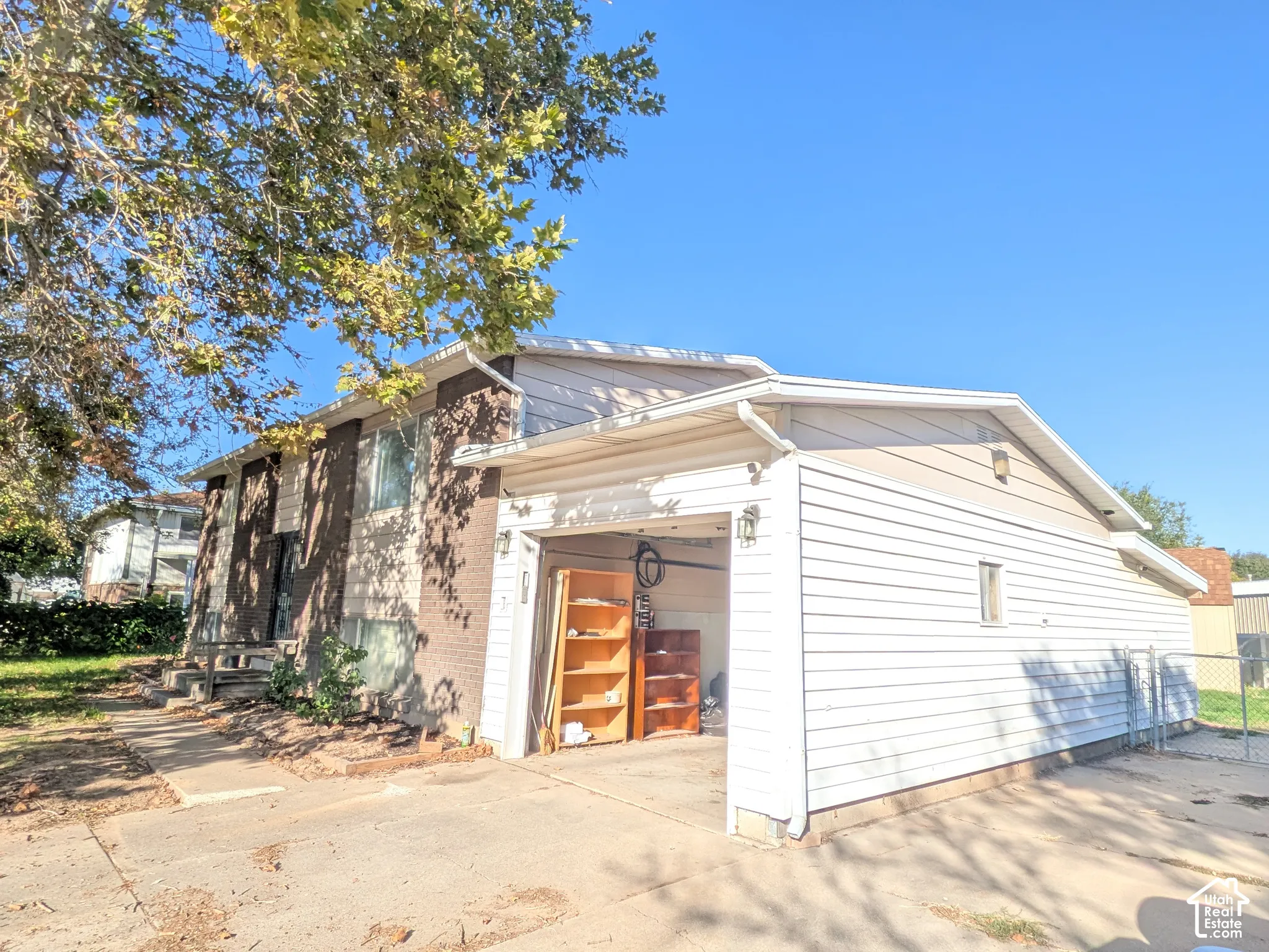 Exterior featuring a brick and siding facade, attached garage, and paved driveway