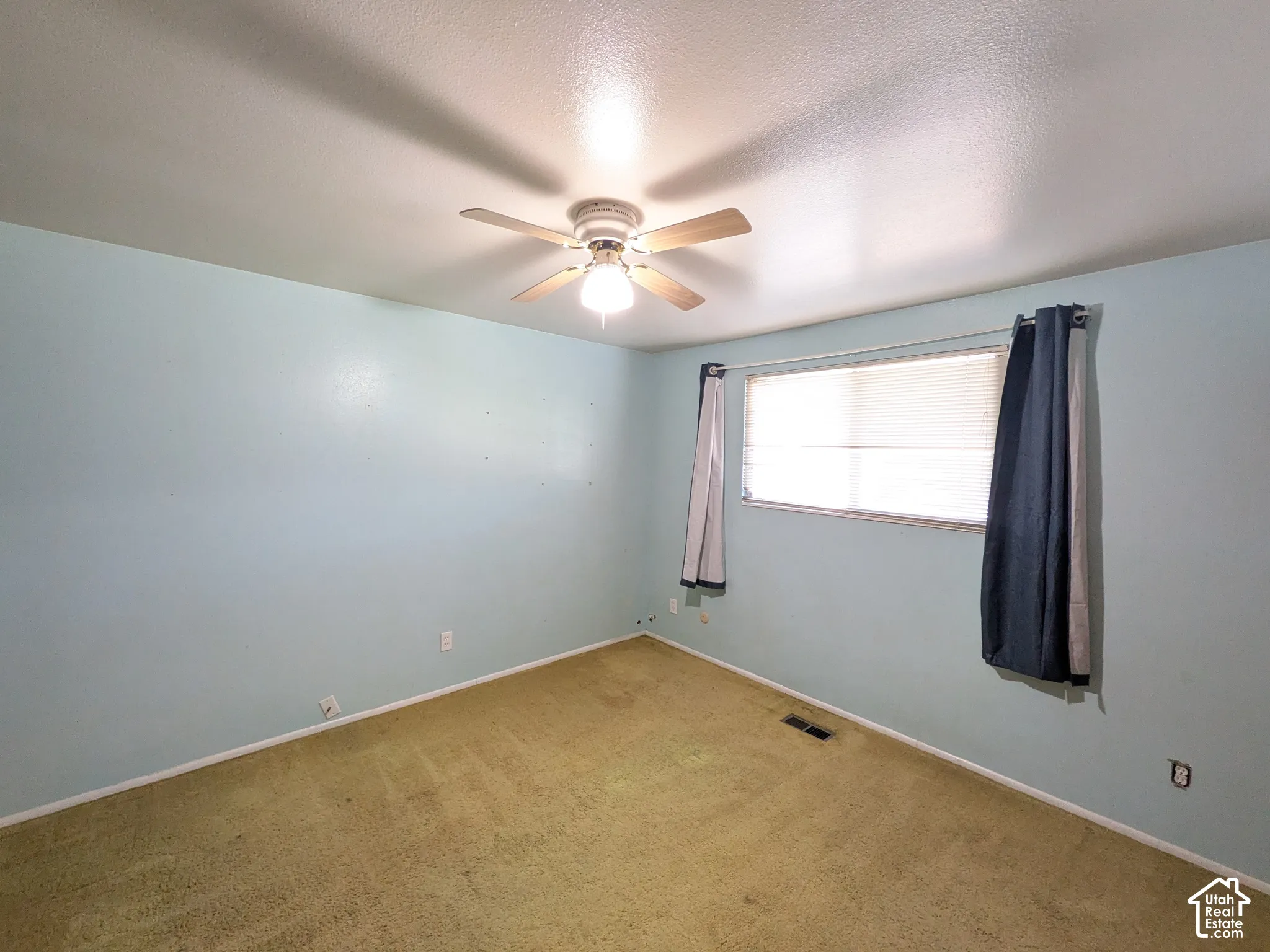 Ceiling fan with light fixture, window with blinds, and wall-to-wall carpeting
