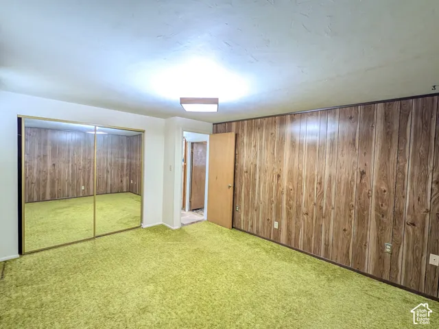 Wall paneling with wood-tone finish, mirrored closet doors, and recessed ceiling lighting