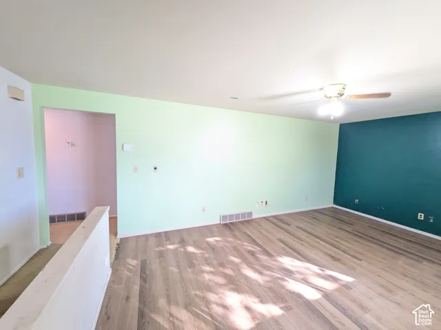 Wood-finish flooring with a ceiling fan overhead