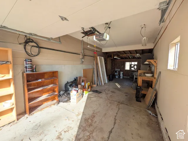 Attached garage featuring concrete flooring and exposed ceiling beams