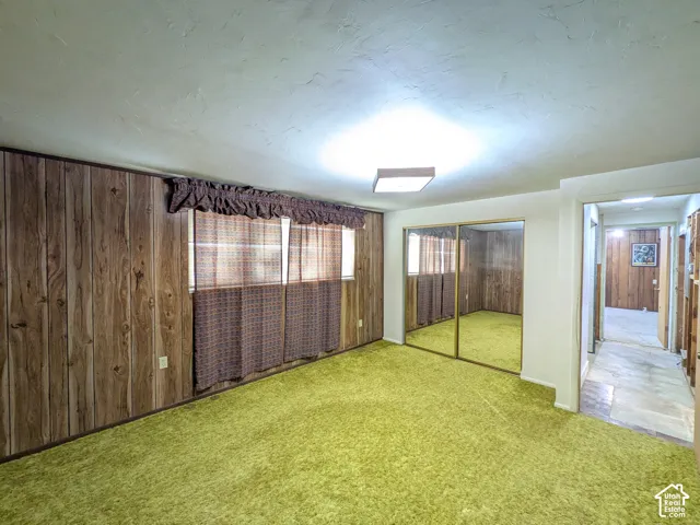 Wood-finish wall paneling, full-height mirrored closet doors, and textured ceilings