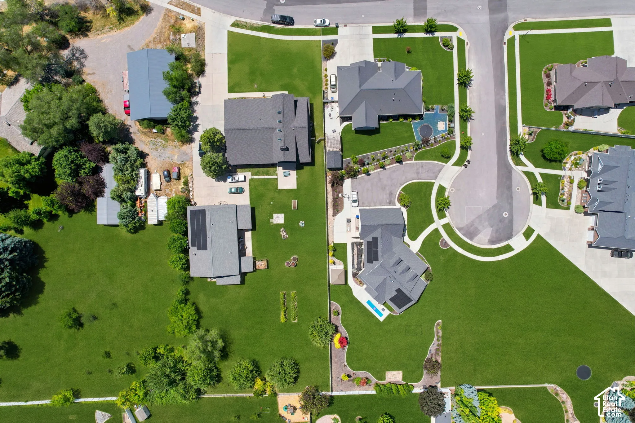 Aerial representation of a residential area featuring multiple properties with expansive green lawns and mature landscaping