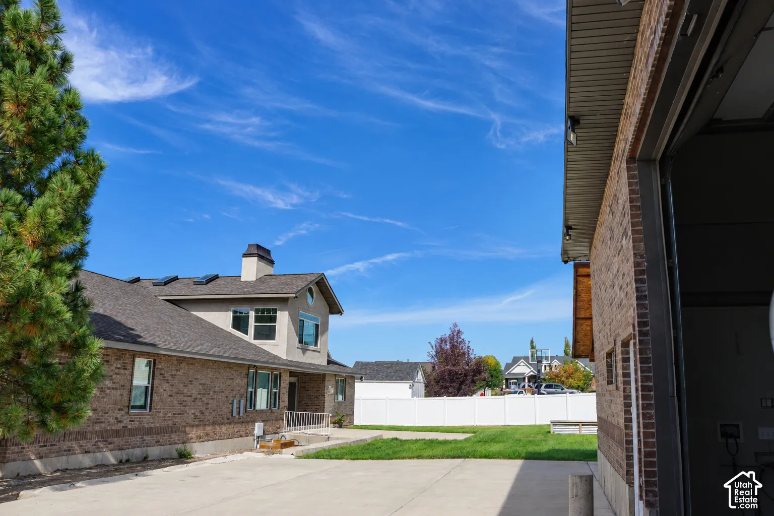 Brick exterior with a complementary stucco facade, gray shingle roof, and a concrete driveway