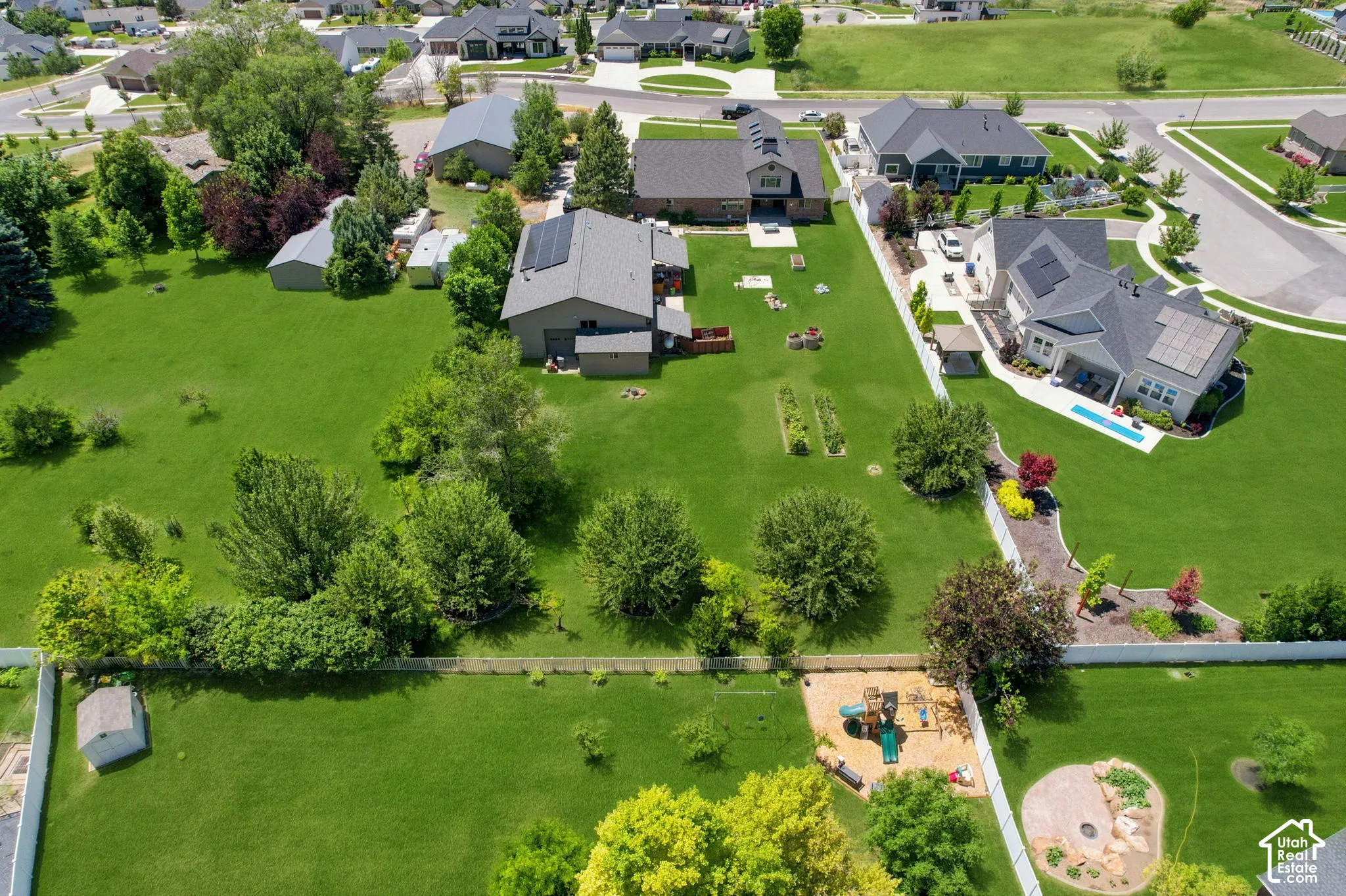 Expansive green landscape featuring mature trees and a manicured lawn