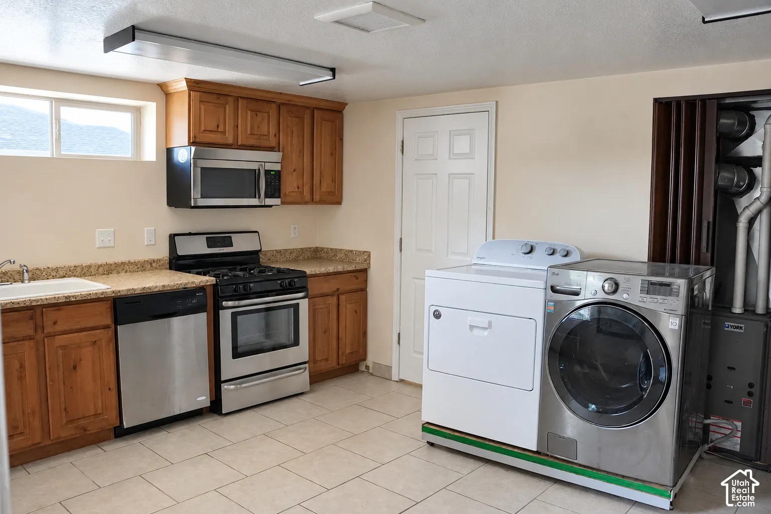 Kitchenette featuring wood cabinetry, stainless steel appliances, and a gas range