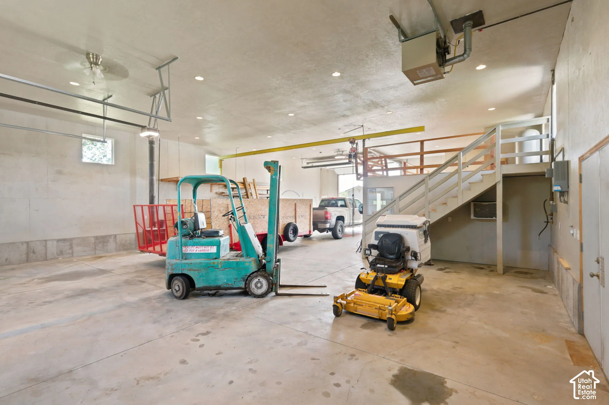 Spacious interior featuring a concrete floor, high ceilings with recessed lighting, and an overhead garage door