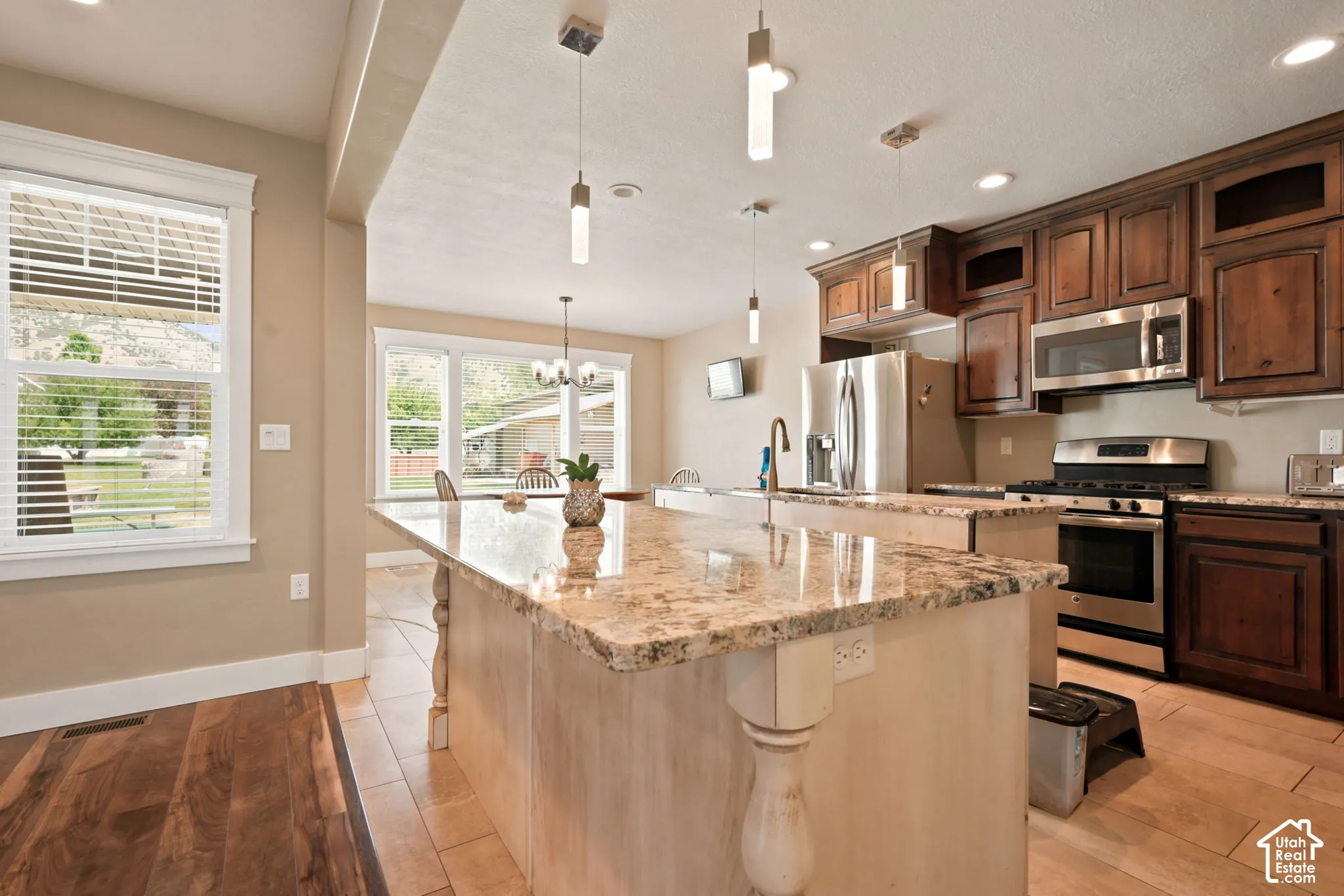 Kitchen featuring a large central island with a light-colored stone countertop and decorative corbels