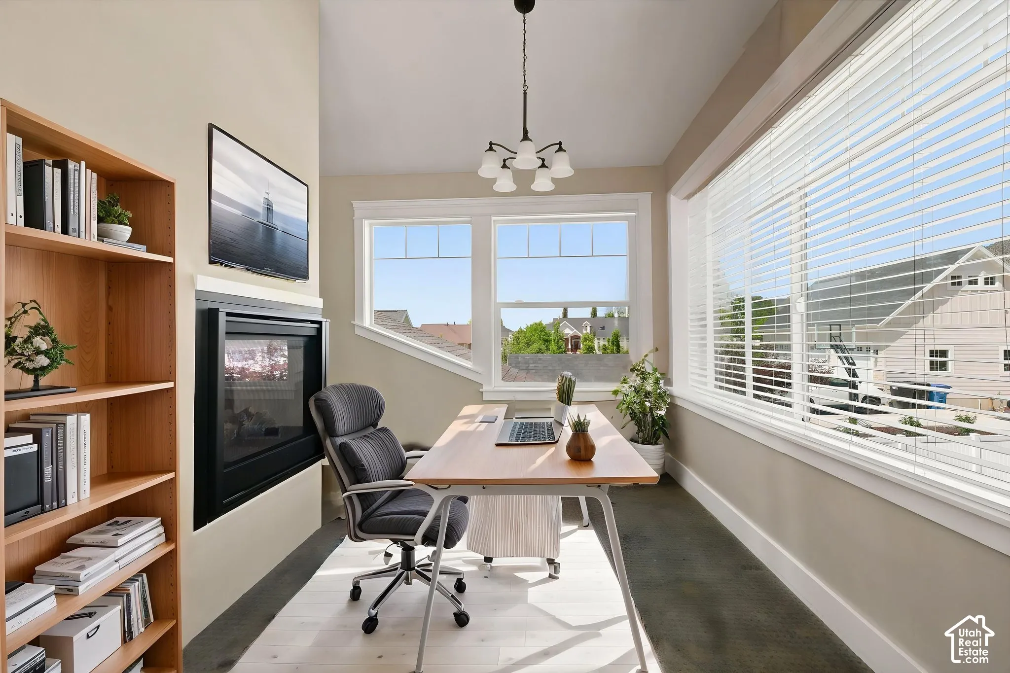 Versatile room featuring a built-in fireplace, natural wood-finish shelving, and expansive   Digitally staged.
