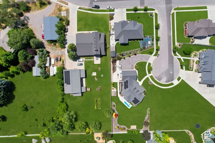 Aerial representation of a residential area featuring multiple properties with expansive green lawns and mature landscaping