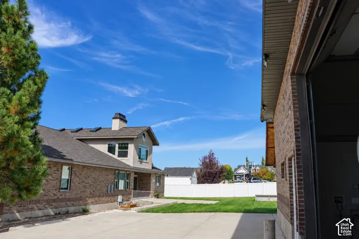 Brick exterior with a complementary stucco facade, gray shingle roof, and a concrete driveway