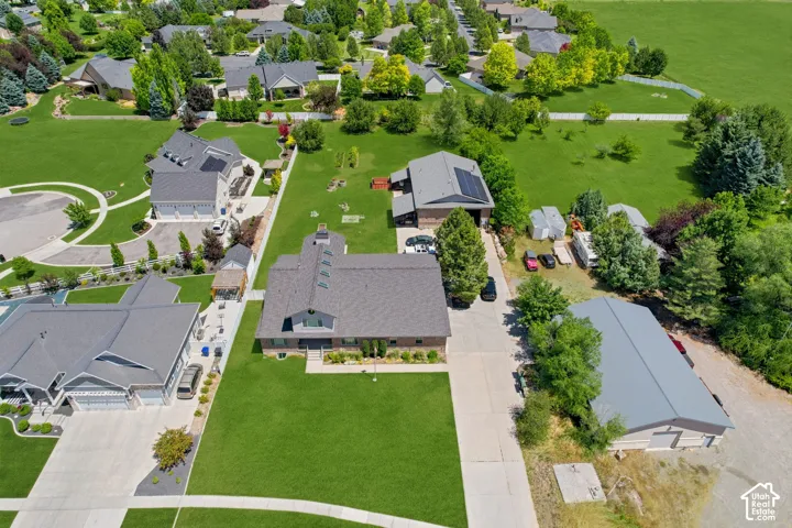 Expansive property featuring a large primary residence, a detached secondary structure with a gray roof, and substantial green   Digitally staged.