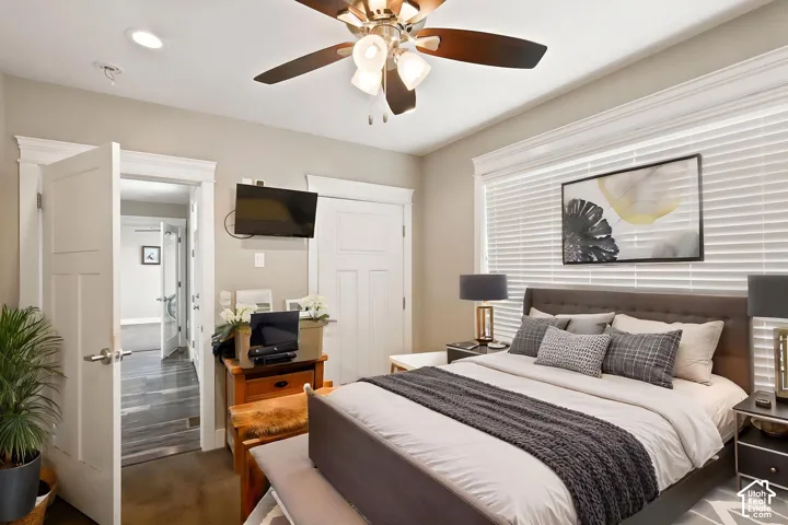 Exterior access bedroom featuring a ceiling fan with integrated lighting, recessed lighting, and a window with   Digitally staged.