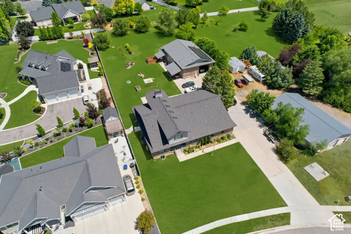 Expansive property featuring a large residence with an attached multi-car garage, a detached accessory dwelling unit, a large detached metal-roofed outbuilding, and extensive manicured lawns