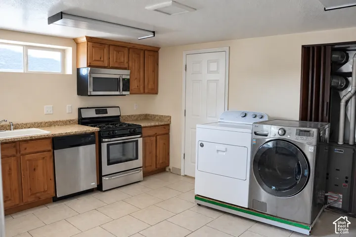 Kitchenette featuring wood cabinetry, stainless steel appliances, and a gas range