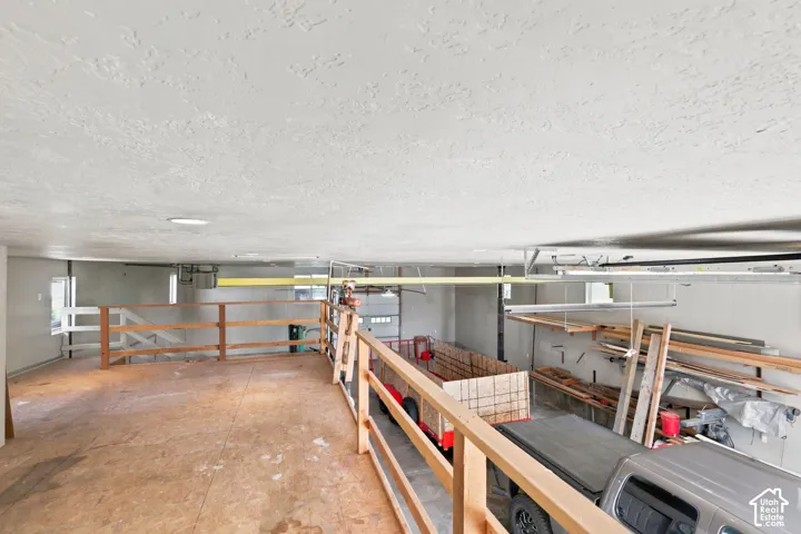 Spacious loft area with wood flooring and natural wood railings