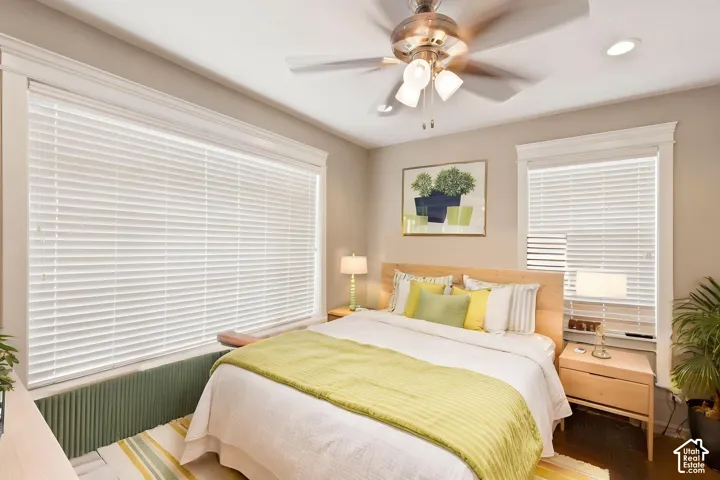 Recessed lighting, a ceiling fan with integrated lighting, and multiple windows with blinds provide ample   Digitally staged.