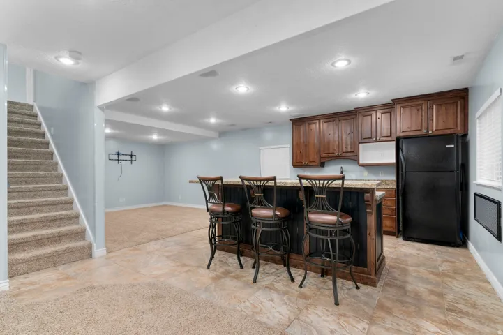 Integrated wet bar with wood cabinetry and countertop