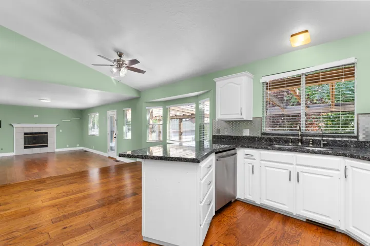 Kitchen island with dark countertops, white cabinetry, and stainless steel appliances