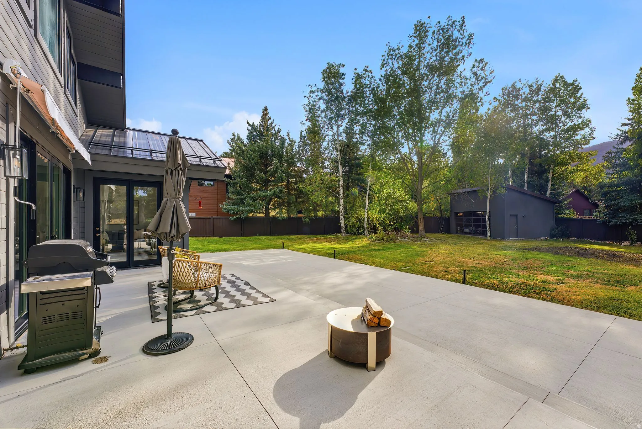 Expansive concrete patio with integrated landscape lighting