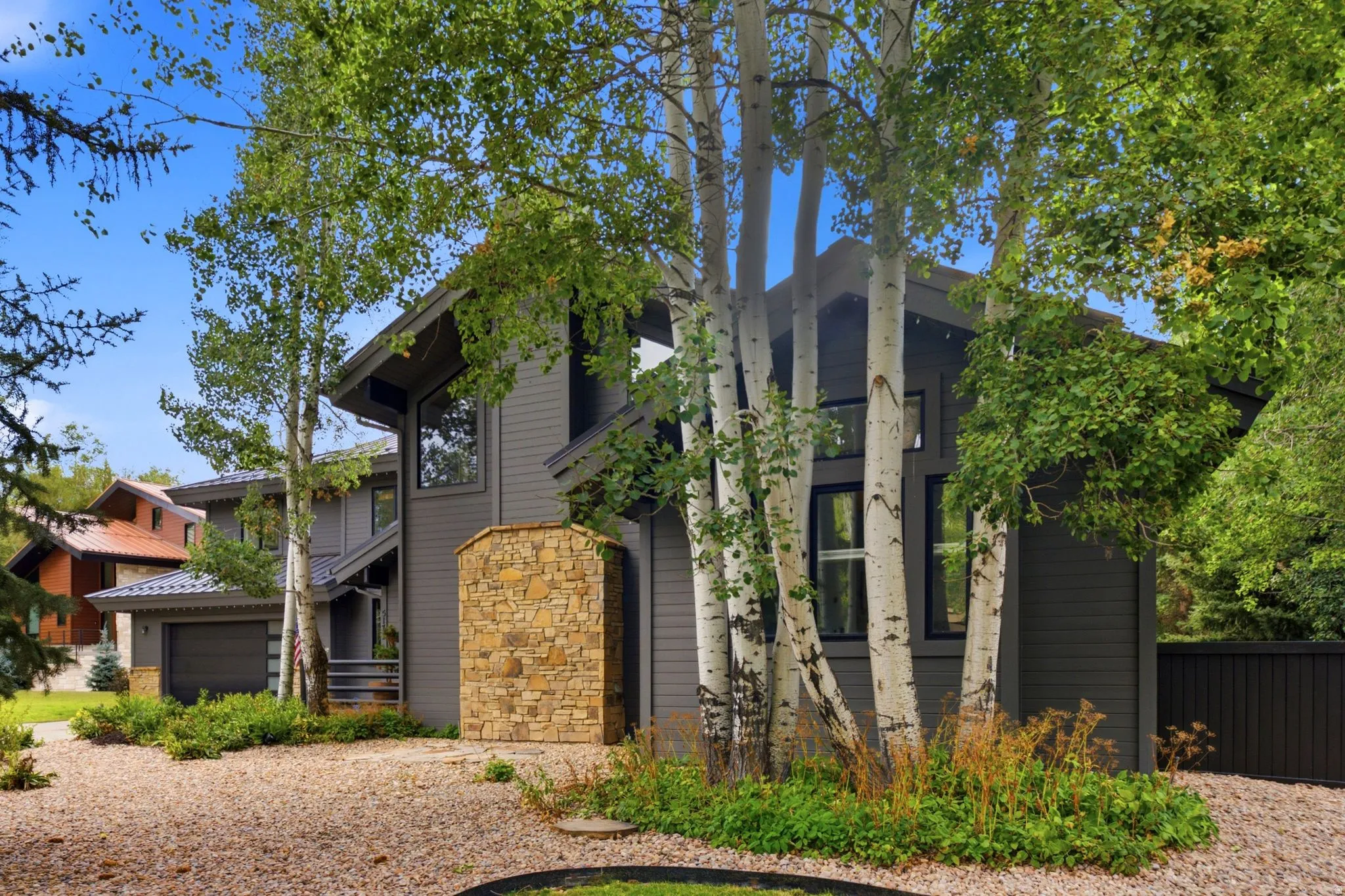 Contemporary exterior with stone facade accents and dark siding