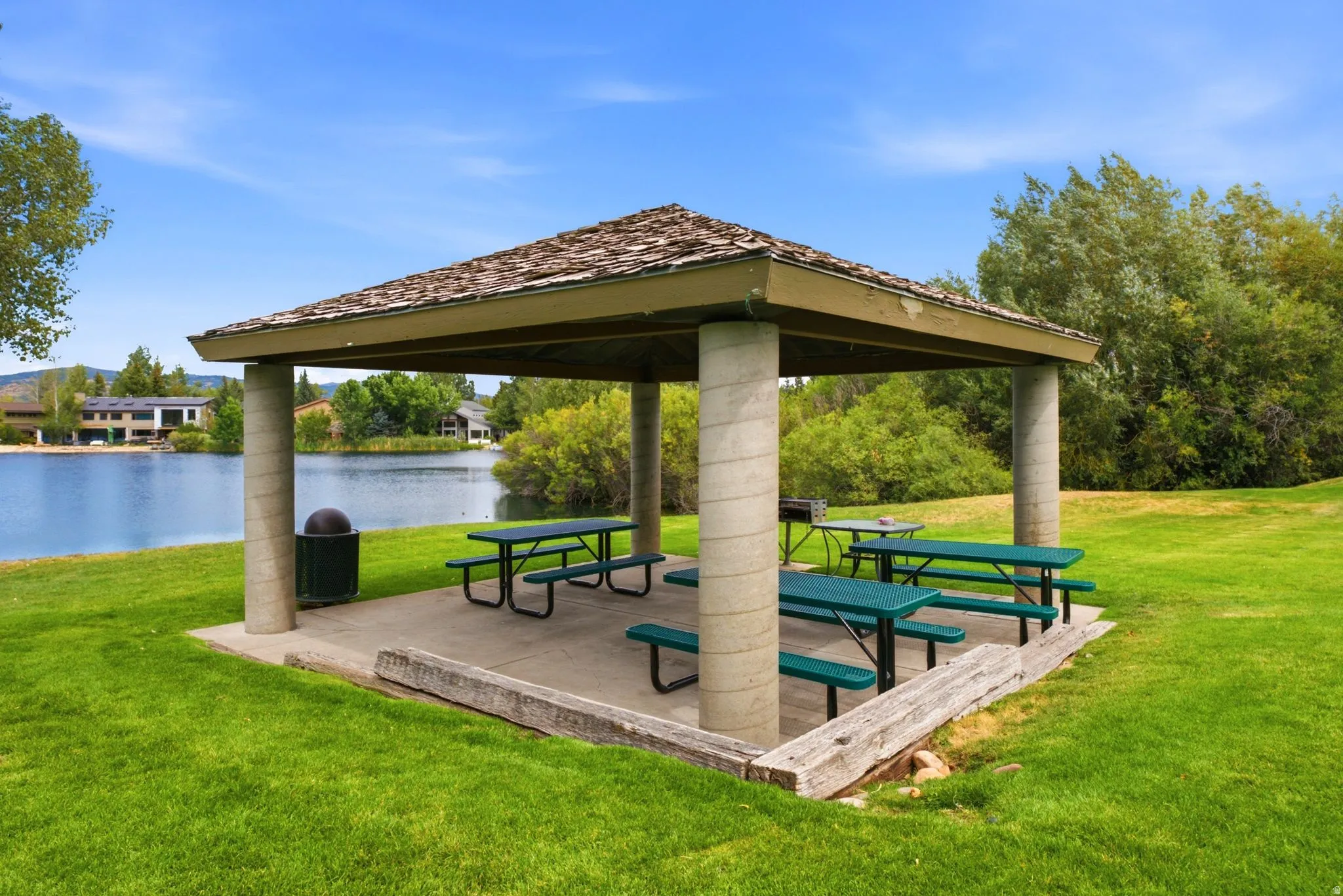 Gazebo with shingle roofing, concrete pillars, and a concrete pad