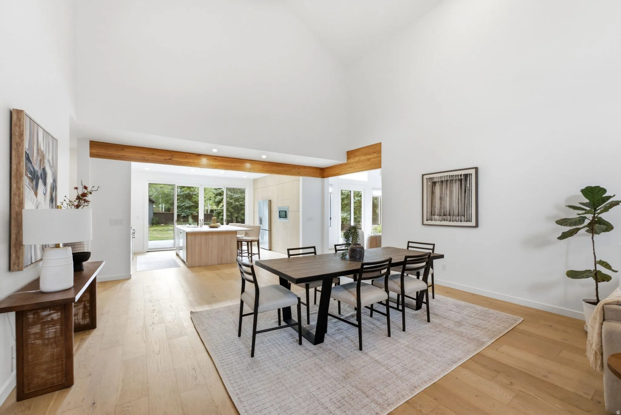 Vaulted ceilings, exposed wood beams, wood-finish flooring, recessed lighting, and expansive glass doors