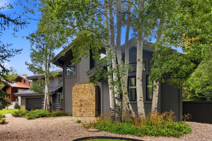 Contemporary exterior with stone facade accents and dark siding