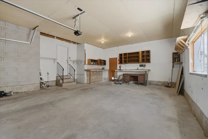 Spacious garage wit, built-in shelving, and a workshop area