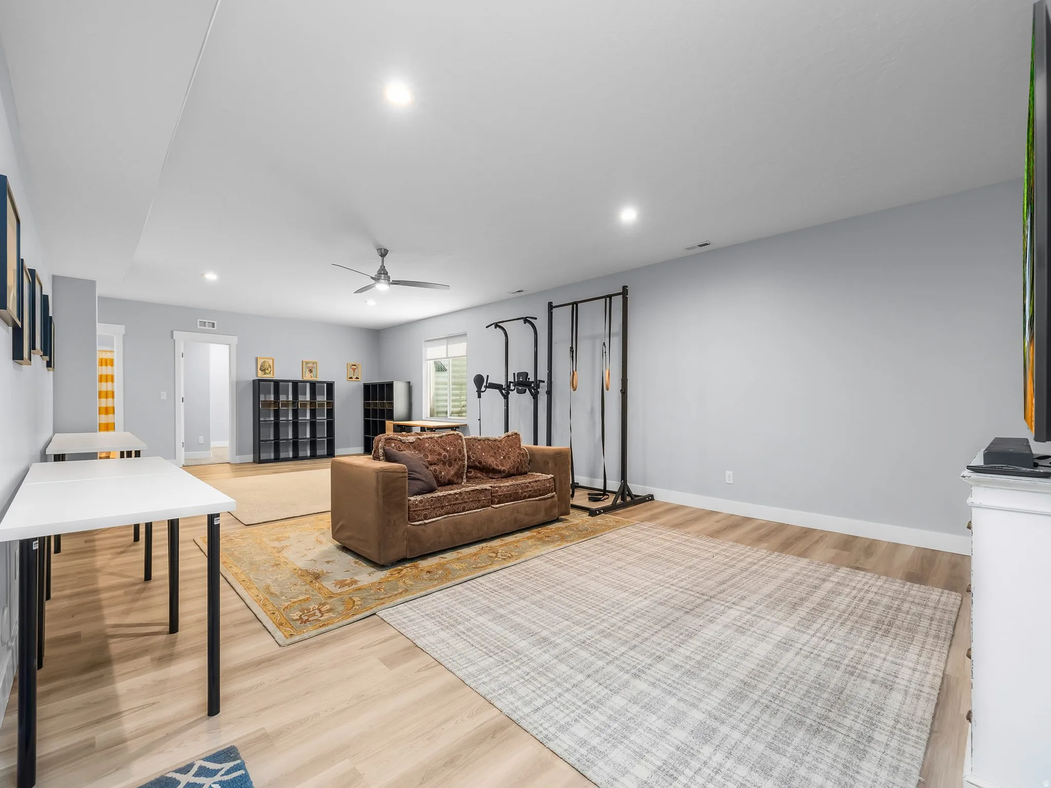 Spacious room featuring wood-finish flooring, recessed lighting, and a ceiling fan