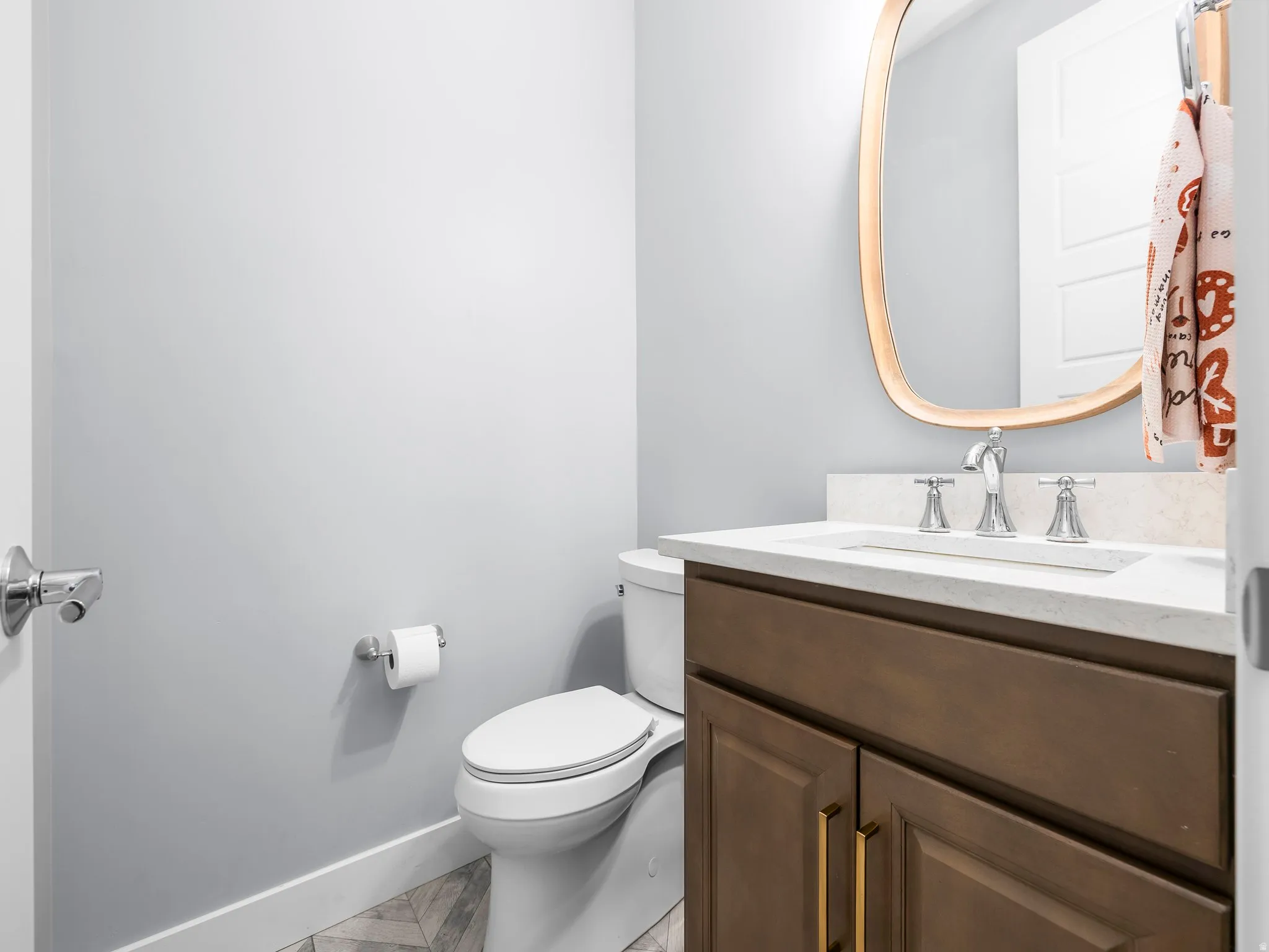 Bathroom vanity with a light-colored countertop, undermount sink, and chrome fixtures