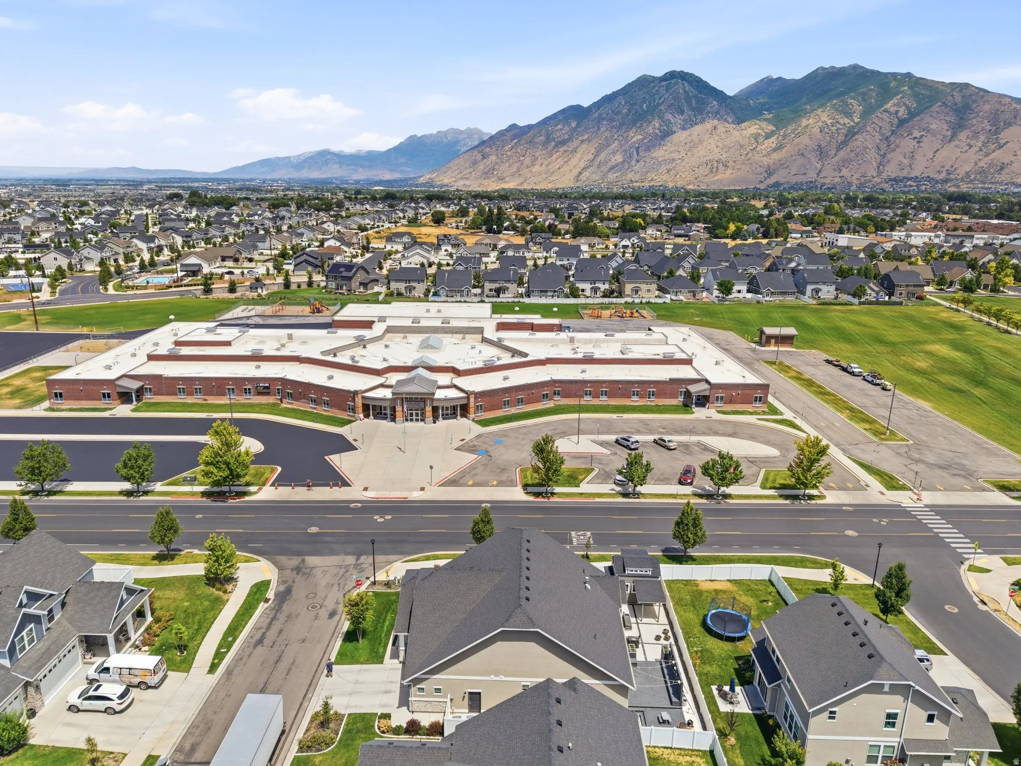 Expansive community featuring modern residential architecture and a large institutional building with brick and stone accents
