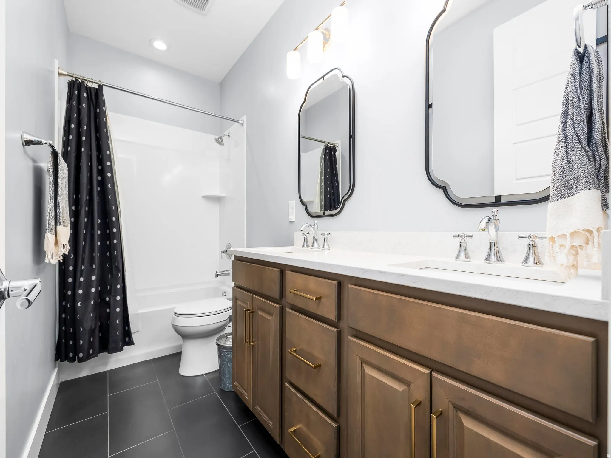 Dual vanity featuring a white countertop, undermount sinks, and bronze-finish hardware