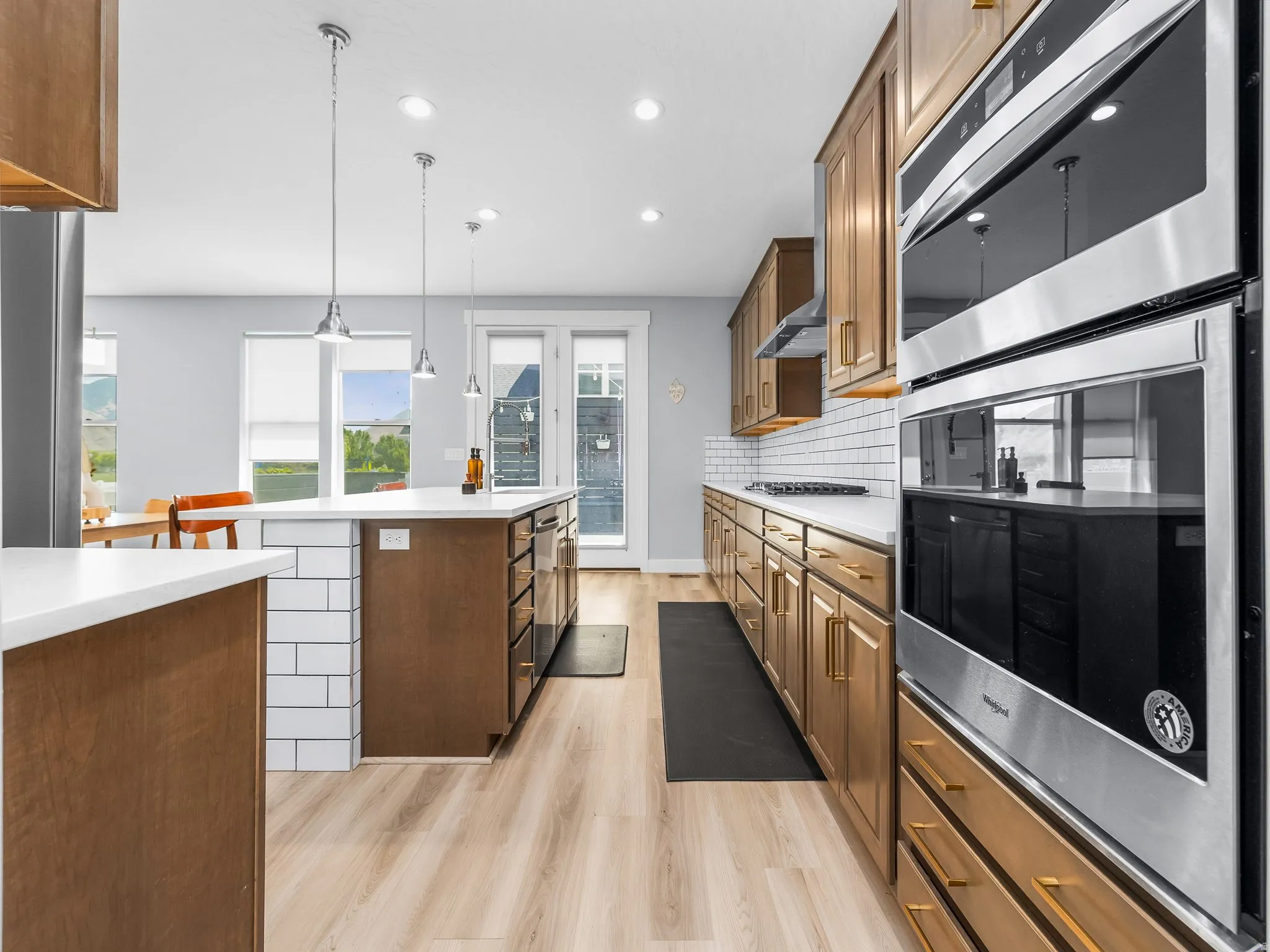 Modern kitchen featuring light wood-finish flooring and white countertops