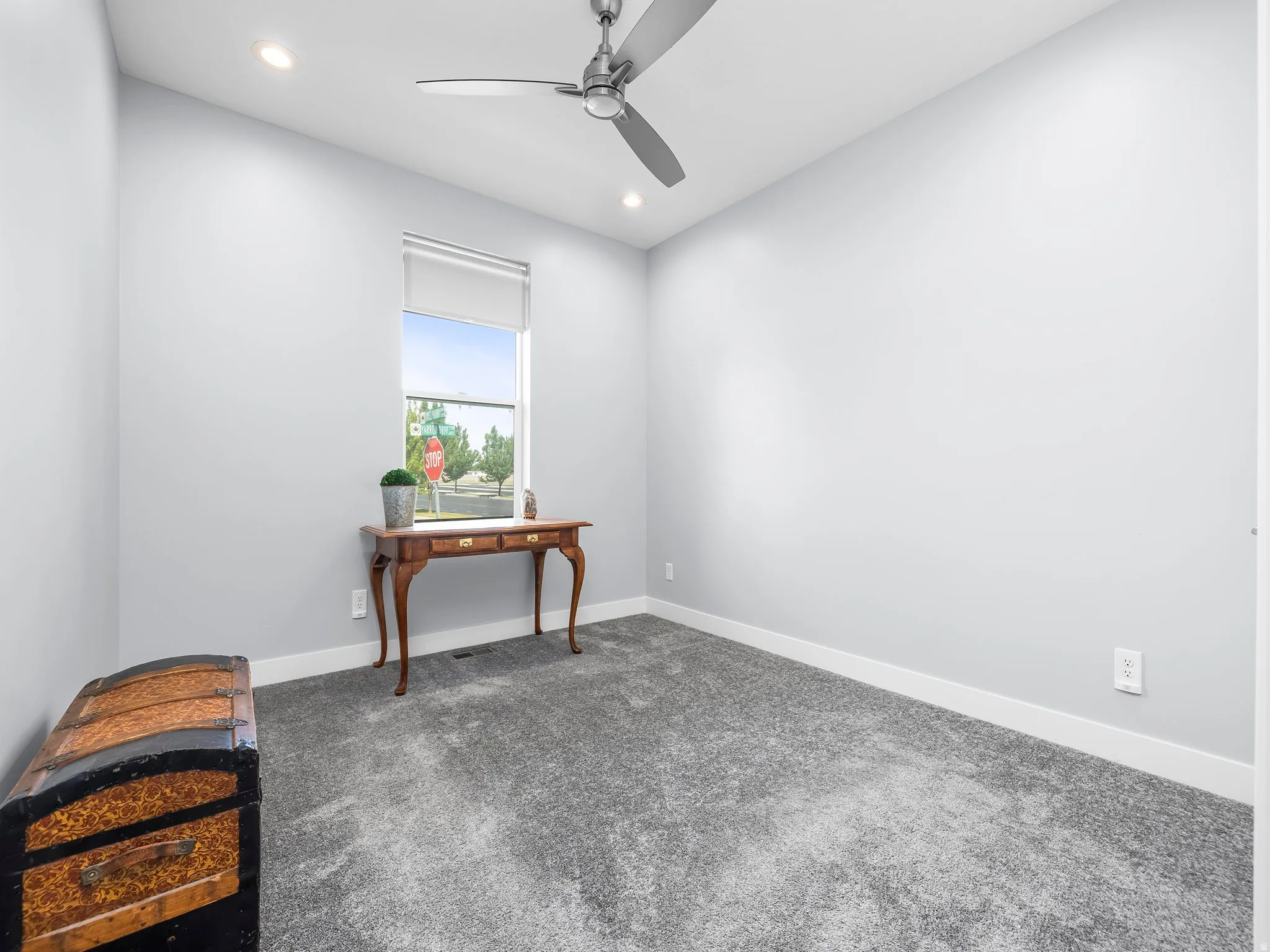 Light gray wall paint complemented by white trim and plush gray carpeting