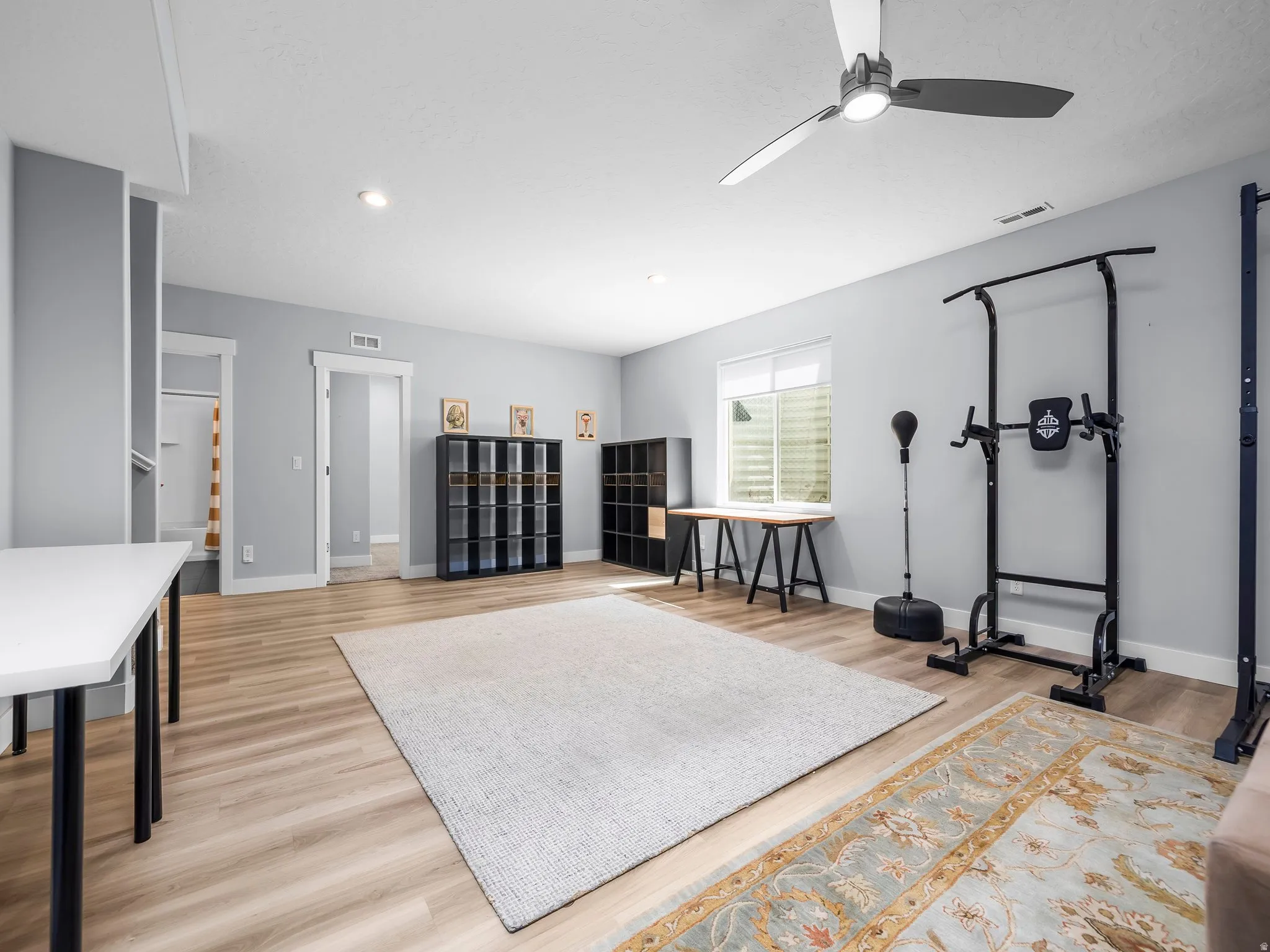 Spacious room featuring wood-finish flooring, recessed lighting, and a modern ceiling fan