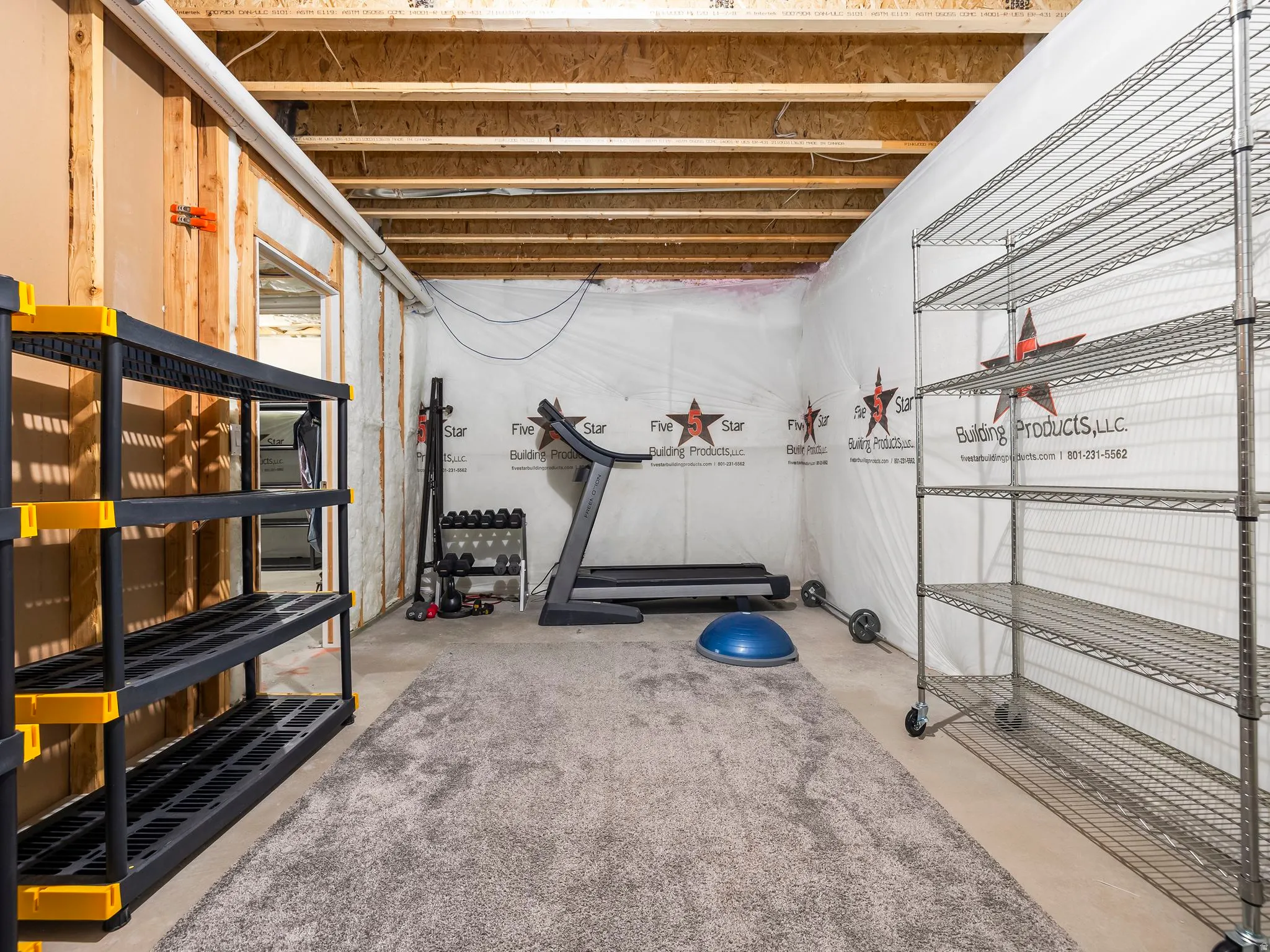Unfinished basement area featuring exposed ceiling joists and wood wall framing