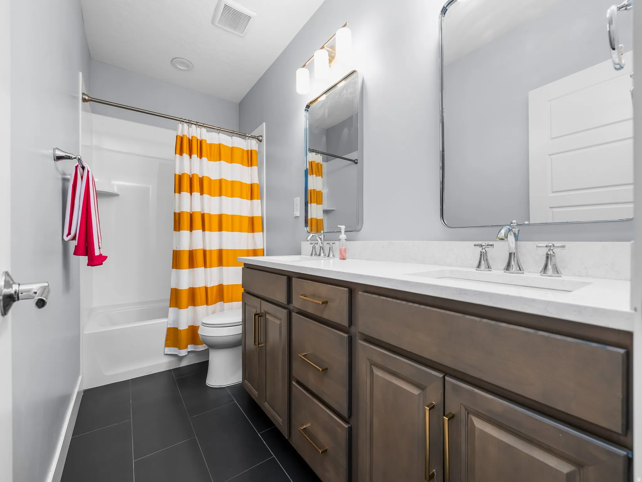 Bathroom featuring a single vanity with a white countertop, chrome faucet, and rectangular mirror