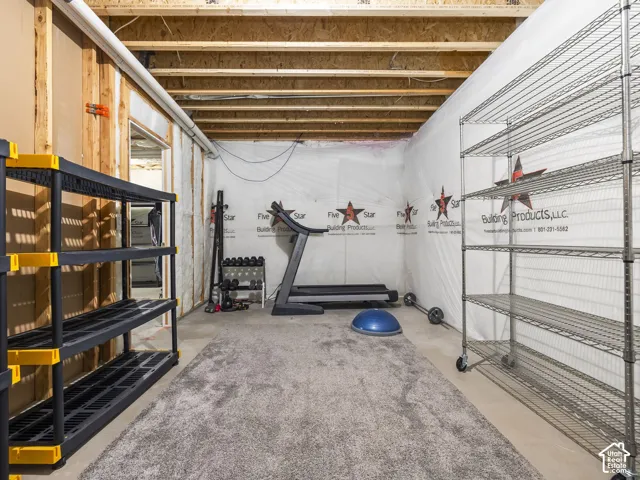 Unfinished basement area featuring exposed ceiling joists and wood wall framing