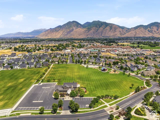 Aerial perspective showcasing a residential community with expansive green spaces and mountainous backdrops
