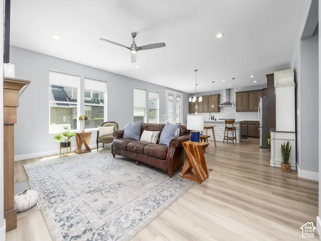 Open-concept living space featuring wood-finish flooring, recessed lighting, and a ceiling fan