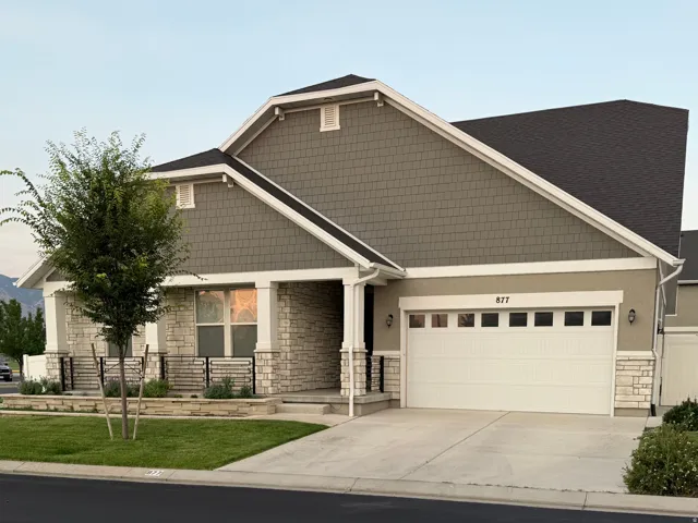 Contemporary residence featuring a gray shingle facade, white trim, and a dark shingle roof
