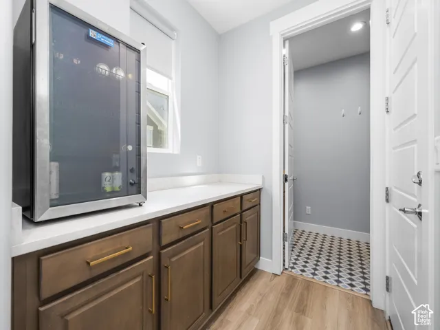 Beverage cooler integrated into the countertop space, featuring wood-finish cabinetry with gold-tone hardware