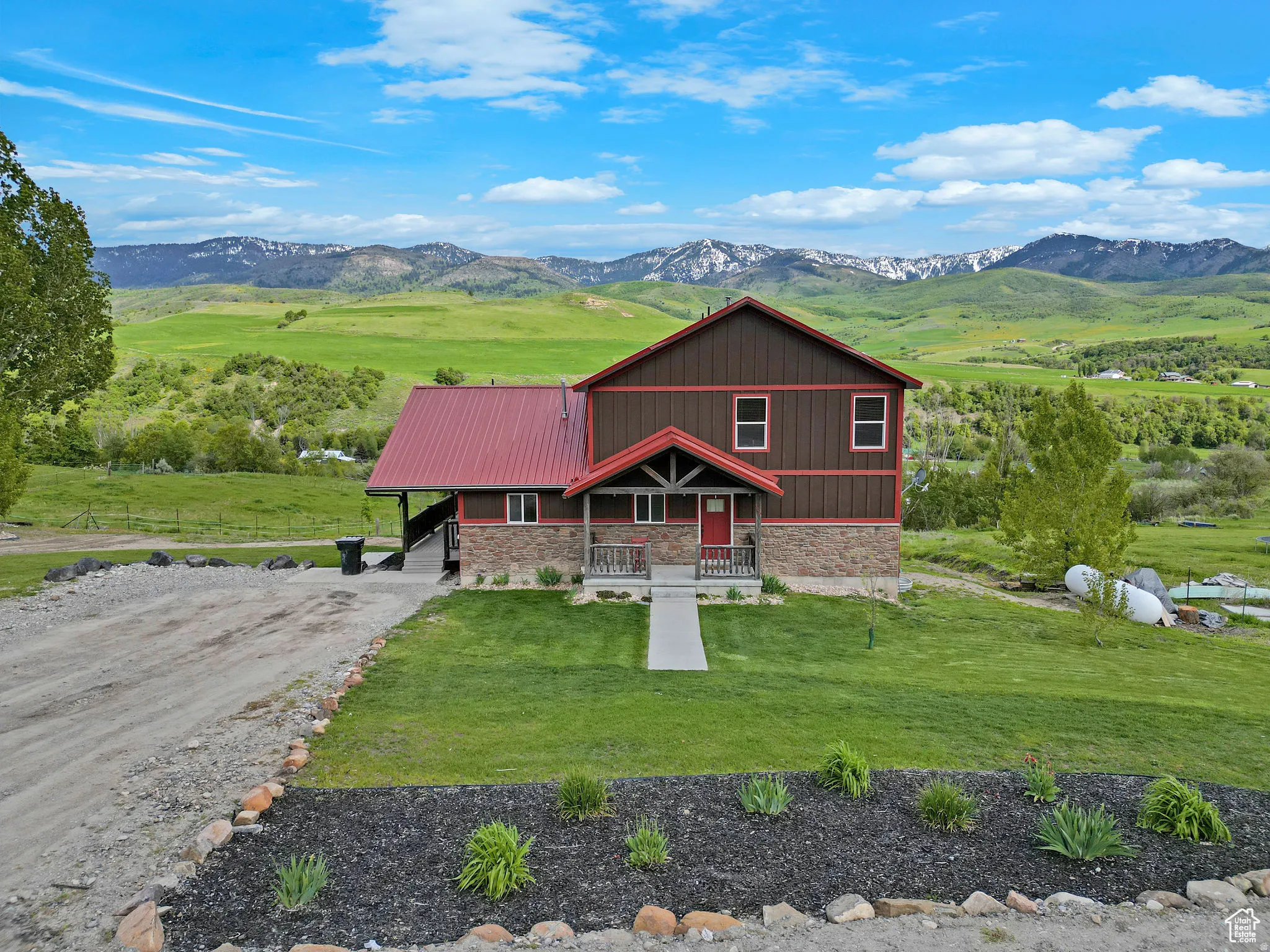 Two-story residence featuring a red metal roof and brown vertical siding