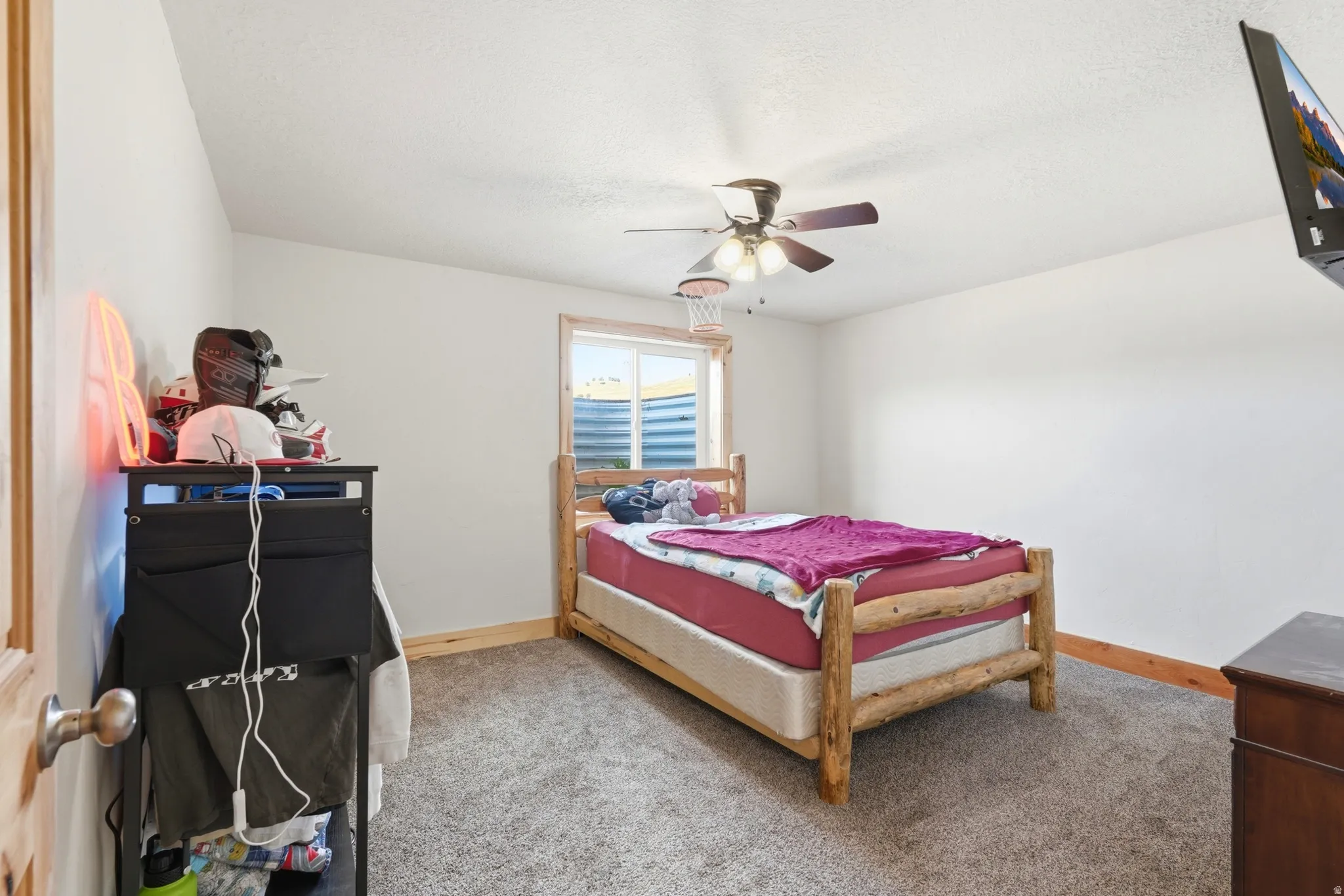Spacious room featuring neutral carpeting, white walls, and natural wood trim